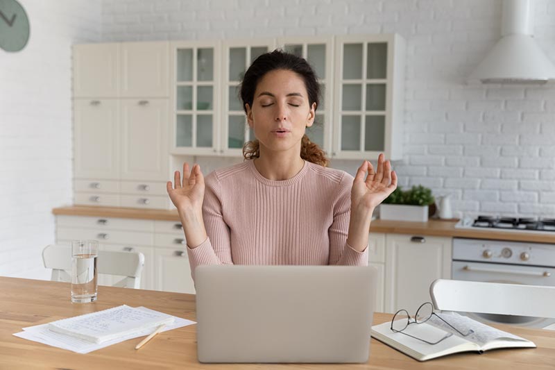 Woman pausing from work to practice coping skills, illustrating stress relief techniques